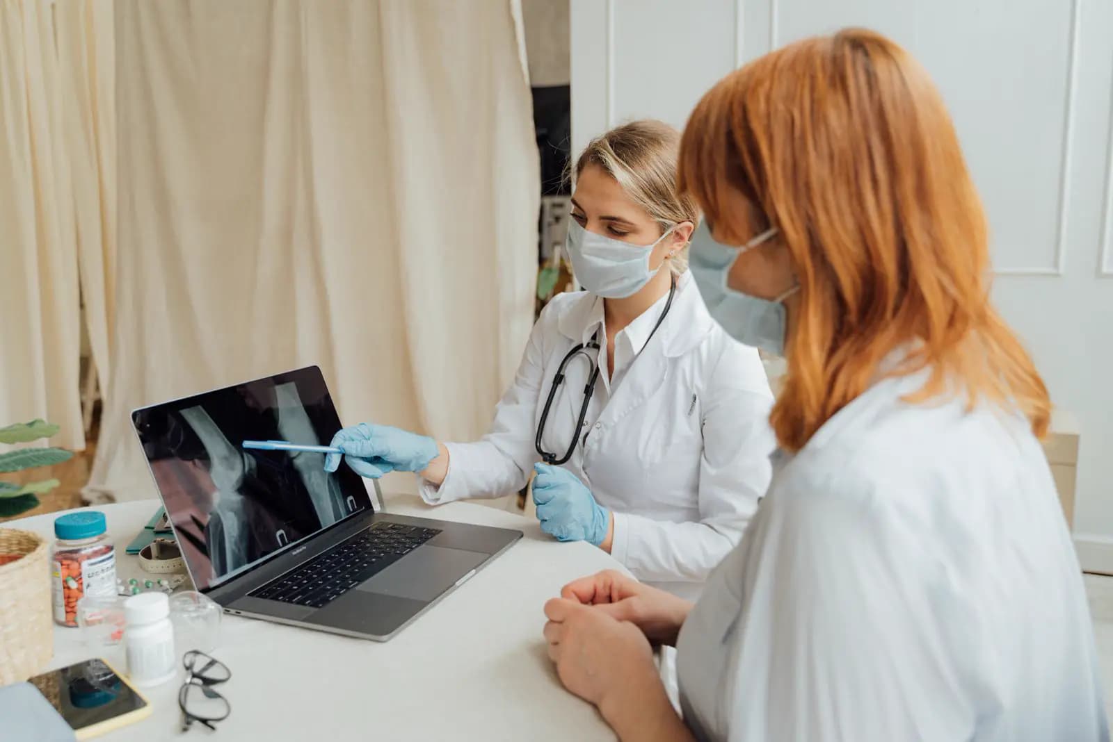 A clinician reviewing an imaging study on a laptop with a colleague