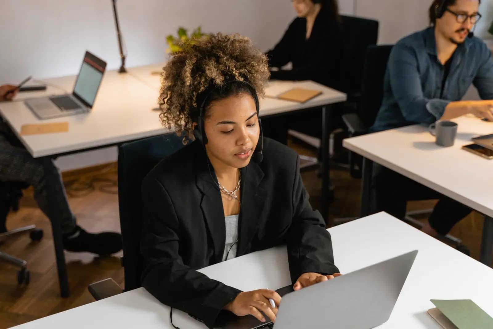 Remote support professionals wearing headsets while working on laptops